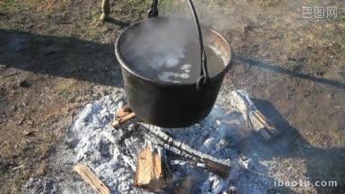 两杯酒，一大锅热气腾腾的液体在篝火上这是一个糖浆制作演示